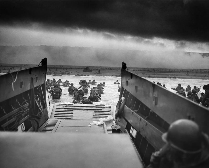 Allied forces landing on Normandy beach under heavy fire